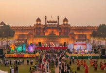 Experience Bharat Parv 2026: India’s Cultural Carnival at Red Fort Crowds enjoying Bharat Parv celebrations at Red Fort, Delhi, with cultural performances, illuminated stalls, and the historic monument glowing at sunset.